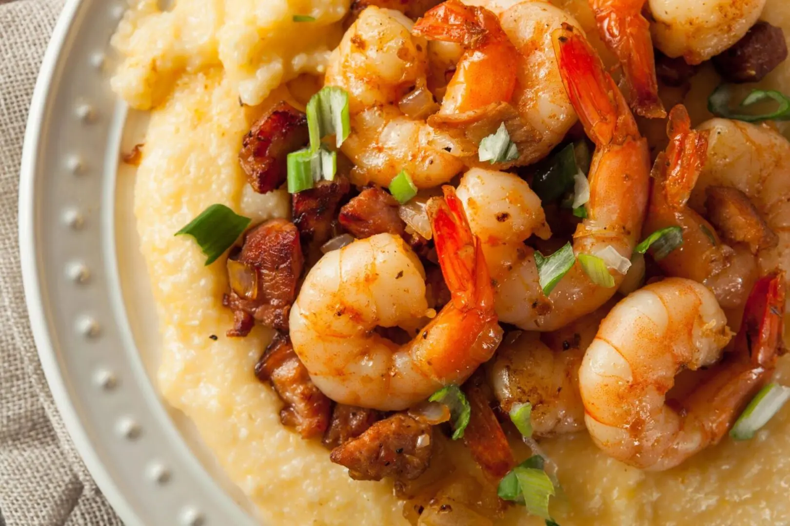 A plate of shrimp and grits with green onions.