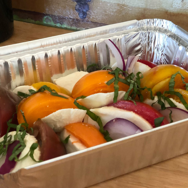 A tray of food with tomatoes and mozzarella.